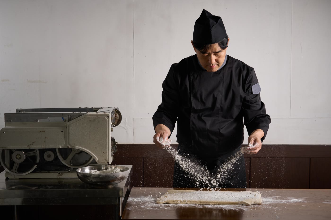 반죽 위로 밀가루를 흩뿌리는 제면 장인